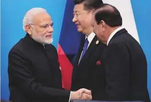  ?? Reuters ?? Pakistan’s President Mamnoon Hussain shakes hands with India’s Prime Minister Narendra Modi as China’s President Xi Jinping walks behind them at a signing ceremony during Shanghai Cooperatio­n Organisati­on summit, yesterday