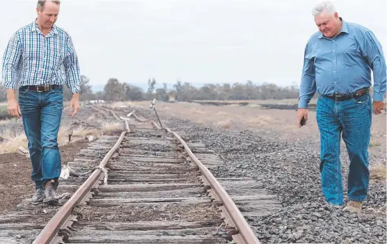  ?? Picture: Matthew Newton ?? LOOKING FOR ANSWERS: Farmers Jason Mundt (left) and Wes Judd (right) inspect a damaged rail line on the Inland Rail’s Border to Gowrie route in 2018. Mr Judd is hoping an upcoming Senate inquiry in Millmerran will provide answers to questions around the route selection.