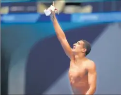  ?? REUTERS ?? 18-year-old Ahmed Hafnaoui of Tunisia celebrates after winning the men’s 400m freestyle gold over his favoured rivals from Australia and the US at the Tokyo Games on Sunday.