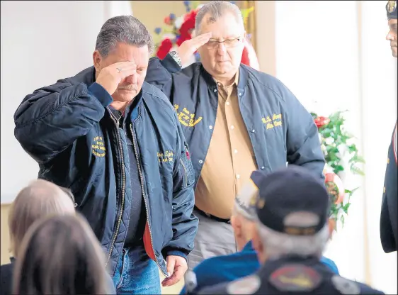  ?? KYLE TELECHAN/POST-TRIBUNE PHOTOS ?? Sons and Daughters of Pearl Harbor Survivors members Joe and Tony Zych salute Pearl Harbor survivor Jim DeWitt during the Pearl Harbor Remembranc­e Day Memorial Service on Saturday at Lincoln Center in Highland.