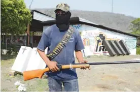  ??  ?? MICHOACAN: An armed resident - a member of a vigilante group - is seen at a check point at the entrance of Buenavista Tomatlan, during an operation to search for criminals in the area called “Tierra Caliente” (Hot Land) in Michoacan State, Mexico on...