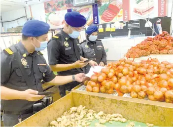  ??  ?? Aslani (middle) and Yapp (left) checking the price of onions at a supermarke­t yesterday.