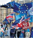  ??  ?? Remain supporters hold placards and flags outside The Palace of Westminste­r