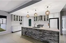  ??  ?? GET COOKING: The impressive open-plan kitchen includes stone bench tops and waterfall edges.