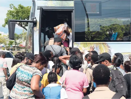  ??  ?? Scores of persons, including students, gather in an effort to board a bus at South Parade in Kingston earlier this year.