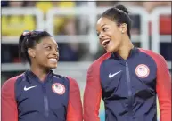  ?? Julio Cortez / Associated Press ?? U.S. gymnasts and gold medalists, Simone Biles, left and Gabrielle Douglas celebrate on the podium during the medal ceremony for the artistic gymnastics women’s team at the 2016 Summer Olympics in Rio de Janeiro, Brazil in 2016.