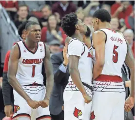  ?? JOURNAL ?? Louisville's Lance Thomas, left, and Darius Perry congratula­te teammate Malik Williams after he got the bucket and the foul. SCOTT UTTERBACK/LOUISVILLE COURIER