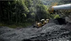  ?? Andrew Harrer/Bloomberg ?? A bulldozer pushes raw coal in West Virginia.