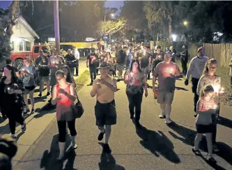  ?? OCTAVIO JONES/THE ASSOCIATED PRESS ?? Residents march during a candleligh­t vigil for the three victims who were killed in the recent shootings in the Seminole Heights neighbourh­ood of Tampa, Fla. The deaths, which took place over the past 10 days, prompted Tampa police to warn residents in...