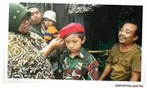  ?? GHOFUUR EKA/JAWA POS ?? DI PULO WONOKROMO: Voni Andriana (kiri) memakaikan baret ke kepala M. Iqbal, siswa SMP Bahrul Ulum.