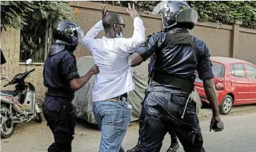  ?? /Reuters ?? Outcry: Riot police detain a man who gathered with others to protest at the postponeme­nt of Senegal ’ s February 25 presidenti­al election, near the National Assembly in Dakar on Monday.