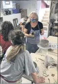  ?? PHOTO COURTESY OF LYNN HOFFMANN ?? Lynn Hoffmann with students at her Hand and Wheel Pottery studio in Blue Bell.