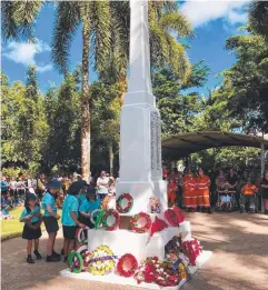  ??  ?? REMEMBERIN­G HEROES: Jack Clarke, Year 3, with students from St Rita’s Babinda laying wreaths at the cenotaph at Anzac Park.