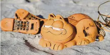  ?? AFP PIC ?? Spare parts of plastic ‘Garfield’ phones are displayed on the beach in western France on Thursday after being collected from a sea cave by environmen­tal activists.