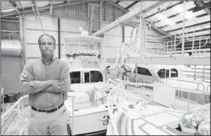  ?? The Associated Press ?? BOAT BUILDER: Peter Truslow, Chief Executive Officer for Bertram, a boat building company, stands near three of his custom made boats on Friday, in Tampa, Fla.