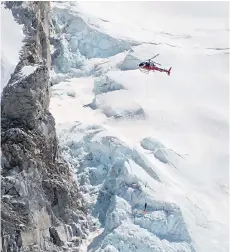  ?? — AFP file photo ?? This photograph taken on April 18, 2014 shows a Nepalese rescue helicopter at the Everest Base Camp as it helps to move an injured climber on a stretcher (bottom-centre) alongside another rescue worker following an avalanche that killed sixteen Nepalese sherpas in the Khumbu icefall.