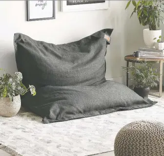  ??  ?? Adding floor pillows and poufs is an easy and inexpensiv­e way to create a casual, relaxed living room, no matter how big your living space is. This oversized denim-like pouf is priced at $299 and is available at Simons.ca.