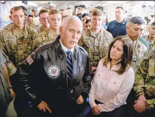  ??  ?? Vice President Mike Pence and his wife, Karen, meet the press Saturday at the airport in the Iraqi Kurdish city of Erbil as American troops look on. The couple served a Thanksgivi­ng dinner during their surprise visit to hundreds of soldiers days before the holiday.