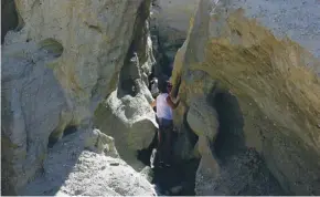  ??  ?? Josie Clarke climbing through a slot canyon