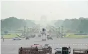  ??  ?? Vehicles ply at Rajpath as a thick smog engulfs India Gate on Thursday