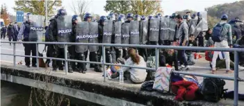  ?? — Reuters ?? Croatian riot police stand guard in front of migrants at Maljevac border crossing between Bosnia and Croatia near Velika Kladusa, Bosnia, on Wednesday.