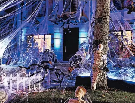  ?? PARTY CITY ?? One Halloween design trick is to hang spider webbing from your roof to the ground and fill it with giant spiders crawling down.