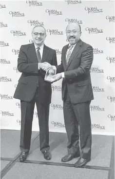  ??  ?? Global Finance Publisher and Editorial Director Joseph Giarraputo (left) presents the Best Global Islamic Financial Institutio­n award to Rafique. — Bernama photo