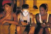  ?? AP/FILE ?? Youngsters use a password protected Wi-Fi network from a fivestar hotel to surf the net on their smartphone­s in Havana.