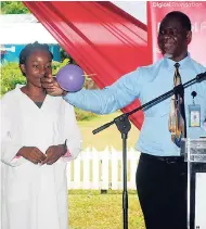  ?? CONTRIBUTE­D ?? National science coordinato­r Sadpha Bennett shows a student just how cool science is, at the launch of a newly renovated science lab at the Buff Bay High School.