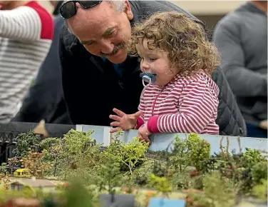  ?? PHOTO: MURRAY WILSON/ STUFF ?? Mike and Phoebe Ryan, 2, take in the the sights at the Rail-x model railway show in Palmerston North.