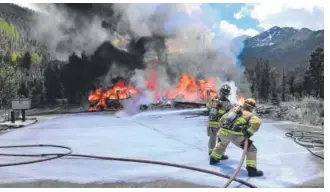  ??  ?? Firefighti­ng crews work to douse a fire from a 2015 crash of a Flight for Life helicopter that killed the pilot and injured two others aboard. Provided by Lake Dillon Fire & Rescue