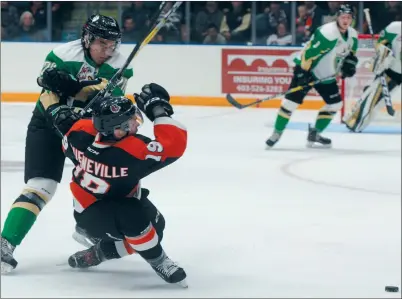  ?? NEWS PHOTO RYAN MCCRACKEN ?? Medicine Hat Tigers defenceman David Quennevill­e is knocked off the puck by Prince Albert Raiders forward Brock Sottile during Saturday’s Western Hockey League game at the Canalta Centre.