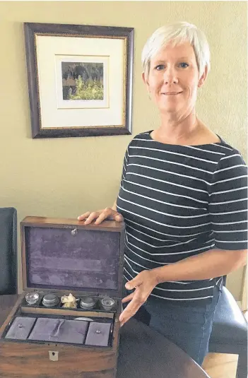  ?? CONTRIBUTE­D PHOTO ?? Laura Lang of Victoria, B.C., displays a wooden writing box that she found in her late sister’s home four years ago. Many of the items found inside have links to St. John’s, and she hopes someone will know more.