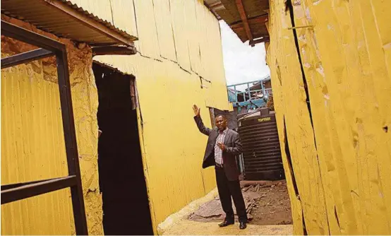  ?? Religion News Service ?? Pastor Steve Shirima, the leader of Jesus Is the Key of Life, shows off his yellow-painted Pentecosta­l church, which is located deep in the slums of Nairobi.