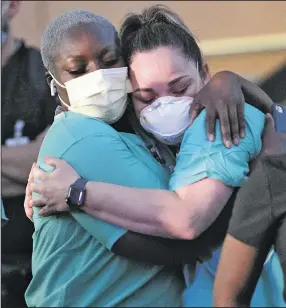  ?? (AP/The Monitor/Delcia Lopez) ?? Addie Adebiyi (left), a registered nurse from Maryland, hugs Rosa Aguirre at a hospital in Edinburg, Texas, where coronaviru­s cases continue to grow.