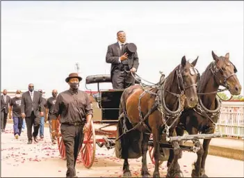  ?? LYNSEY WEATHERSPO­ON GETTY IMAGES ?? A horse-drawn carriage carrying the body of civil rights icon Rep. John Lewis, D-GA., crosses the Edmund Pettus Bridge Sunday in Selma, Ala. Lewis died on July 17 of pancreatic cancer.