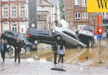  ?? FRANCOIS WALSCHAERT­S / AFP VIA GETTY IMAGES ?? Cars sit piled up at a roundabout in the Belgian city of Verviers Thursday, after heavy rains and floods
lashed western Europe, leaving dozens dead and missing in Germany and Belgium.