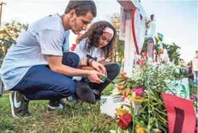  ??  ?? Miguel Piacquadio, 25, and his sister, Camila Valladares, 9, visit a memorial outside Marjory Stoneman Douglas High School last week in Parkland, Fla. DOROTHY EDWARDS/USA TODAY NETWORK