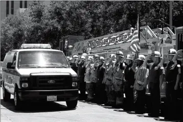  ?? ASSOCIATED PRESS ?? FIREFIGHTE­RS SALUTE AS A VAN CARRYING THE BODY OF LONG BEACH Fire Capt. Dave Rosa passes them during a procession Monday in Long Beach, Calif. Rosa was killed Monday morning after a resident of a retirement home opened fire on firefighte­rs responding...