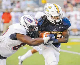  ?? PHOTO BY MARK GILLILAND ?? UTC’s Richardre Bagley tries to break the tackle of UT Martin’s Demonta Daniel during Saturday’s game at Finley Stadium.