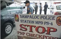  ?? AP PHOTO ?? Policemen watches vehicles at a checkpoint in Manila, Philippine­s, Wednesday as the Philippine National Police is placed under full alert status following the declaratio­n of martial law in Mindanao southern Philippine­s.