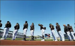  ?? ELAINE THOMPSON — THE ASSOCIATED PRESS ?? San Diego Padres players and coaches line up during playing of the national anthem before a spring training game against the Dodgers in Peoria, Ariz.