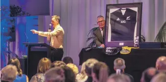  ?? WARWICK SMITH/MANAWATŪ STANDARD ?? From left, Auctioneer Phil Transom and John Turkington present an All Black jersey signed by Richie McCaw at a gala to raise money for women’s sport coaching.