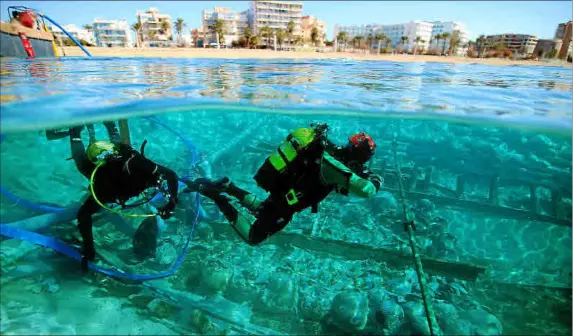  ?? Foto: CONSELL/UIB ?? Dos buzos trabajando sobre el pecio de Ses Fontanelle­s realizando labores de extracción de las ánforas.