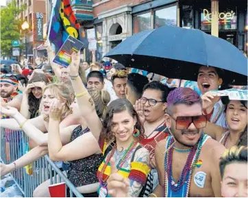  ??  ?? People watch at Roscoe and Halsted streets in the rain on June 30, 2019, at the 50th Chicago Pride Parade.