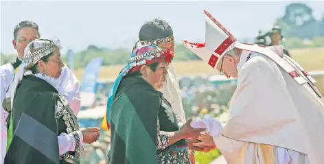  ??  ?? El papa Francisco acepta la ofrenda de una mujer mapuche, durante la misa multitudin­aria realizada ayer en la Base Aérea de Maquehue, en Temuco, Chile.