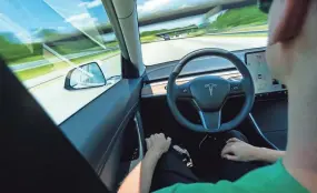  ?? DREAMSTIME.COM VIA TNS ?? Tesla instructs drivers to keep hands on the steering wheel when Autopilot is engaged, but not all drivers do.