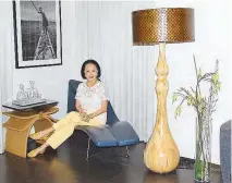  ??  ?? Nonie Basilio sits beside a most eye-catching floor lamp