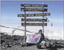  ??  ?? Dr. Dharmesh Patel holds up his American Heart Associatio­n flag after reaching the summit of Mt. Kilimanjar­o.