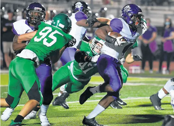  ?? KYLE TELECHAN/POST-TRIBUNE PHOTOS ?? Merrillvil­le’s Lavarion Logan, right, tries to slip a tackle by Valparaiso’s Nathan Craft on Friday.